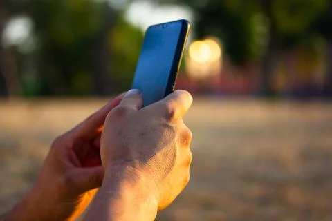 Cell phone in man's hands. Faceless male, guy uses smartphone, cellphone in hand Foto stock