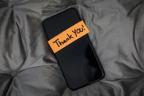 A cell phone with a note on it that says "Thank You" Stock Photos