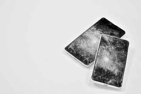 Cell phone with the screen broken by a hammer. Stock Photos