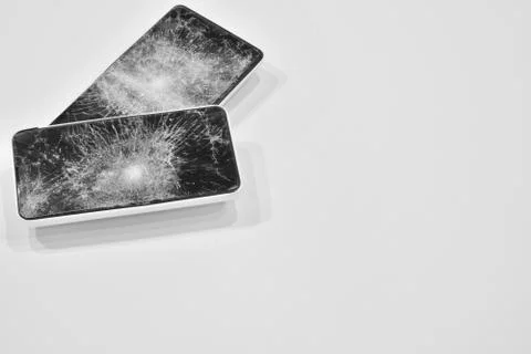 Cell phone with the screen broken by a hammer. Stock Photos