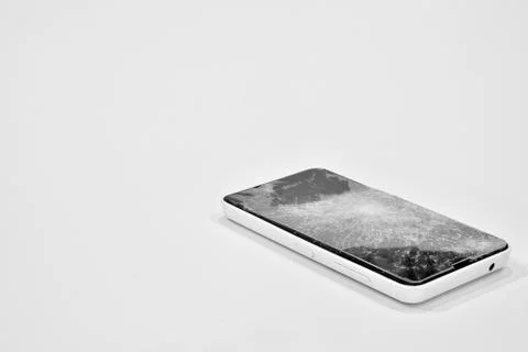 Cell phone with the screen broken by a hammer. Stock Photos