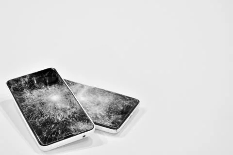 Cell phone with the screen broken by a hammer. Stock Photos