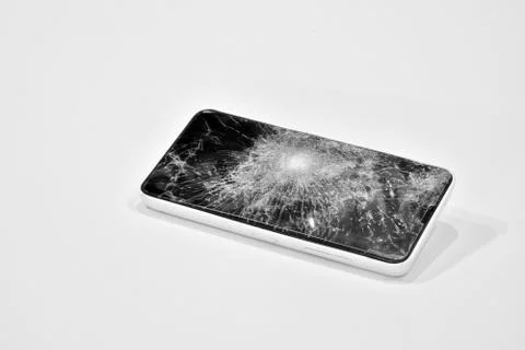 Cell phone with the screen broken by a hammer. Stock Photos