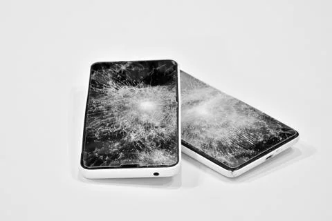 Cell phone with the screen broken by a hammer. Stock Photos