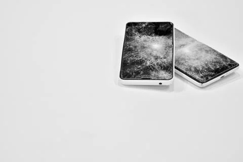 Cell phone with the screen broken by a hammer. Stock Photos