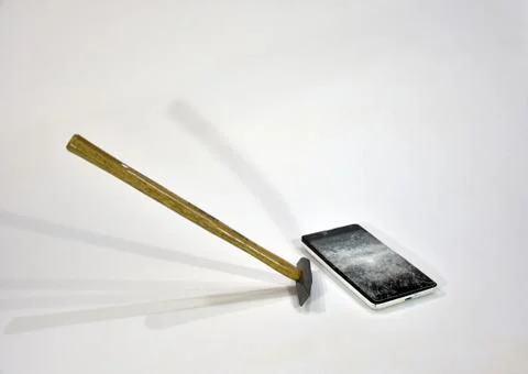 Cell phone with the screen broken by a hammer. Stock Photos