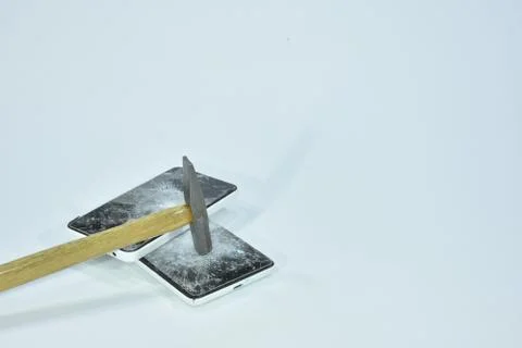 Cell phone with the screen broken by a hammer. Stock Photos