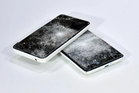 Cell phone with the screen broken by a hammer. Stock Photos