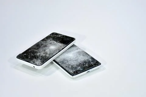 Cell phone with the screen broken by a hammer. Stock Photos