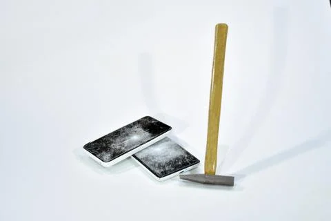 Cell phone with the screen broken by a hammer. Stock Photos