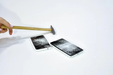 Cell phone with the screen broken by a hammer. Stock Photos