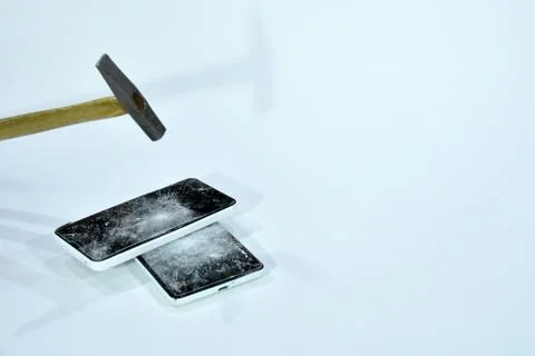 Cell phone with the screen broken by a hammer. Stock Photos