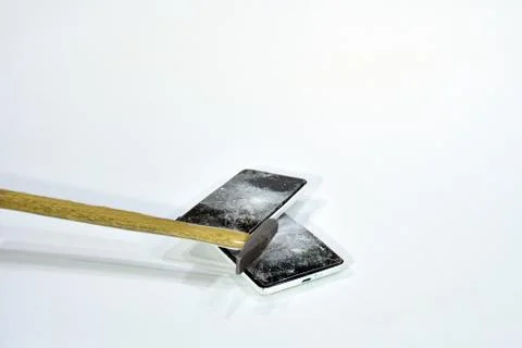 Cell phone with the screen broken by a hammer. Stock Photos