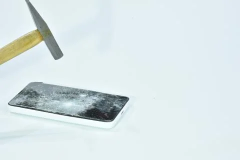 Cell phone with the screen broken by a hammer. Stock Photos