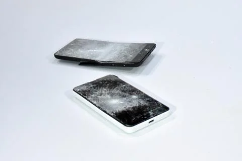 Cell phone with the screen broken by a hammer. Stock Photos