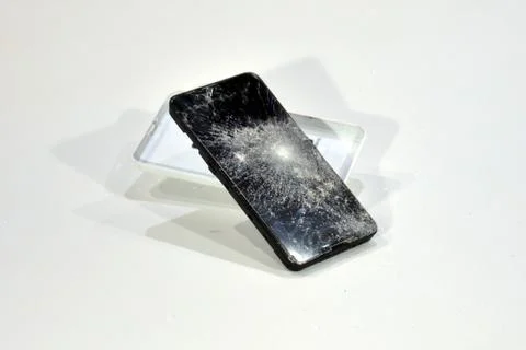 Cell phone with the screen broken by a hammer. Stock Photos