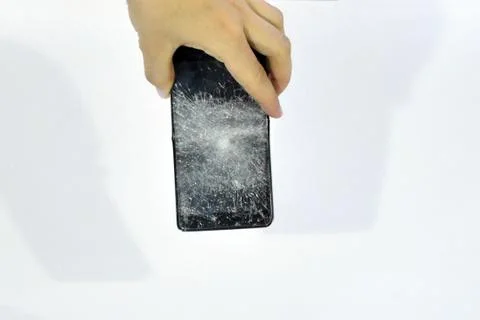 Cell phone with the screen broken by a hammer. Stock Photos