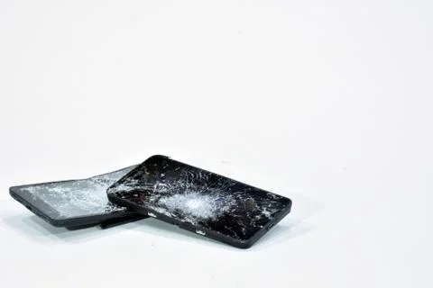Cell phone with the screen broken by a hammer. Stock Photos