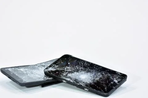 Cell phone with the screen broken by a hammer. Stock Photos