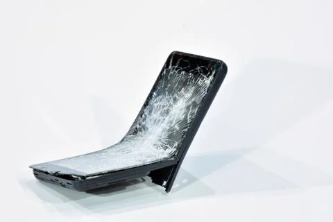 Cell phone with the screen broken by a hammer. Stock Photos