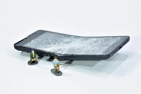 Cell phone with the screen broken by a hammer. Stock Photos