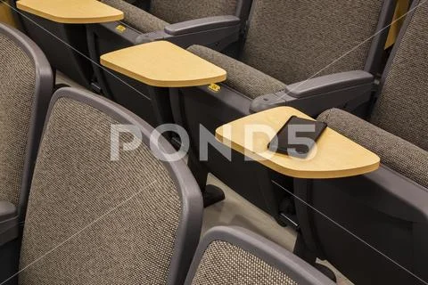 Cell phone on a students desk in an empty college lecture hall Stock Photos