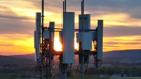Cell tower during orange sunset. Aerial orbit with long zoom. Connectivity Stock Footage 242014818
