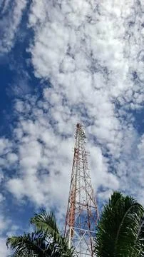 Cell Tower Reaching Upward Into Blue Sky and Clouds Stock Photos