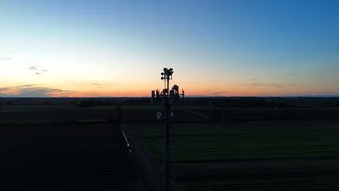 Cell tower rises above ploughed Po Valley fields at twilight, broadcasting .. Stock Photos