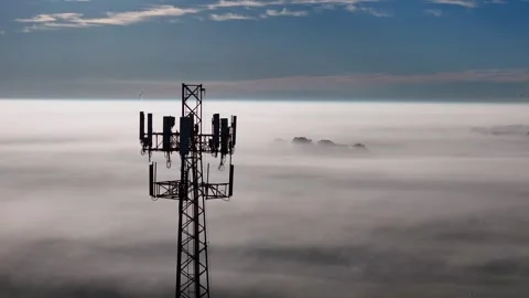 Cell tower rising above dense fog layer, connecting networks over clouds Video stock 327604865