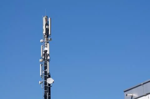 Cell tower telecom mast with 5G antennas against blue sky in Mendrisio, Swi.. Stock Photos