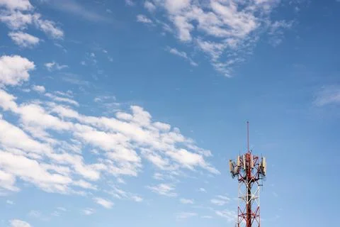 Cell tower under blue sky with clouds Stock Photos