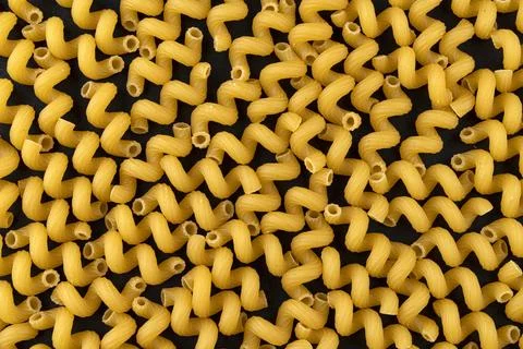 Cellentani pattern on black background, top view, flat lay texture Stock Photos