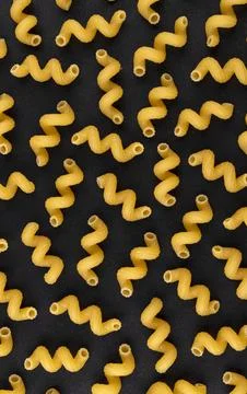 Cellentani pattern on black background, top view, flat lay texture Stock Photos