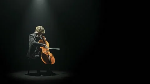 Cellist is playing his cello alone on stage Stock Footage 64523993
