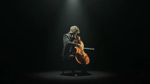 Cellist is playing his cello alone on stage Stock Footage 64524250