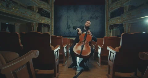 A cellist plays against the backdrop of a beautiful opera house, a magnificent 動画素材 303432580