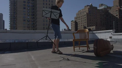 Cellist setting up on New York rooftop Stock Footage 111042396