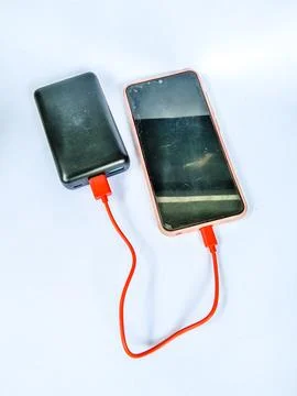 Cellphone being charged using a power bank with isolated white background Stock Photos