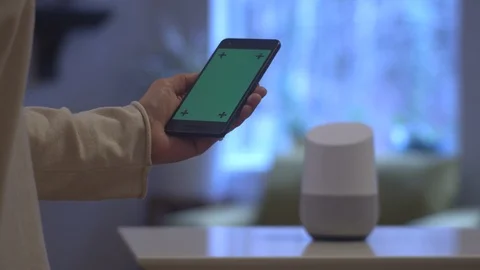 Cellphone with green screen turning on a Google home Stock Footage 102195025