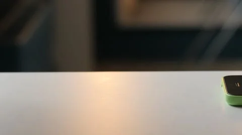 Cellphone lying on a table and man typing a message. Dolly shot Stockbeeldmateriaal 68991504