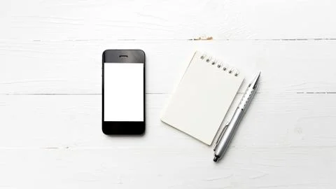 Cellphone with notepad and pen Stock Photos