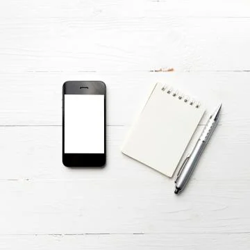 Cellphone with notepad and pen Stock Photos