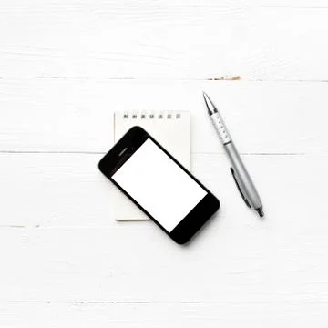 Cellphone with notepad and pen Stock Photos