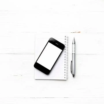 Cellphone with notepad and pen Stock Photos