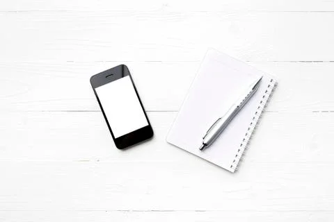 Cellphone with notepad and pen Stock Photos