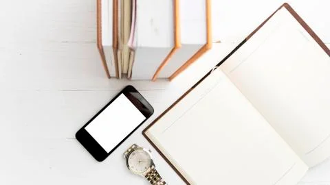 Cellphone with stack of book and watch Stock Photos