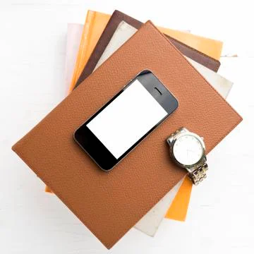 Cellphone with stack of book and watch Stock Photos