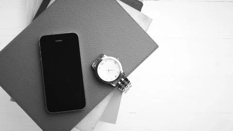 Cellphone with stack of book and watch black and white tone color style Stock Photos