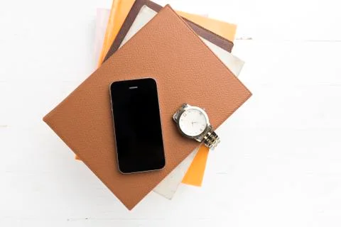 Cellphone with stack of book and watch Stock Photos